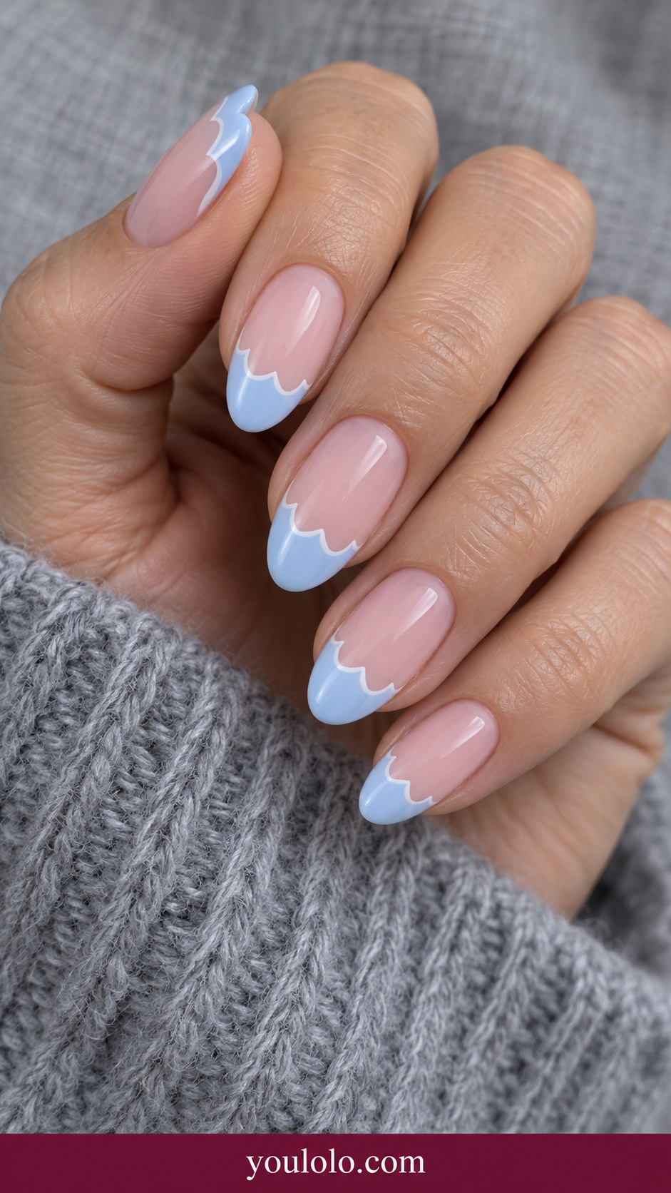 medium almond sheer pink nails French edge of three rounded pale blue scallops with fine white border, smooth glossy on a naturally relaxed adult hand