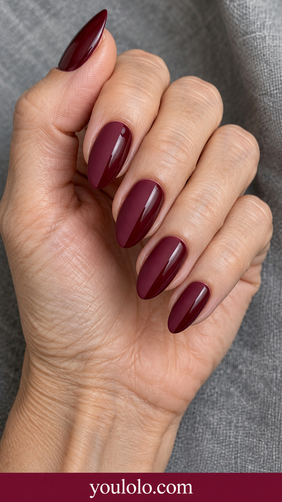 Polished Wine Almond: plain polished deep wine almond nails on a naturally posed adult hand