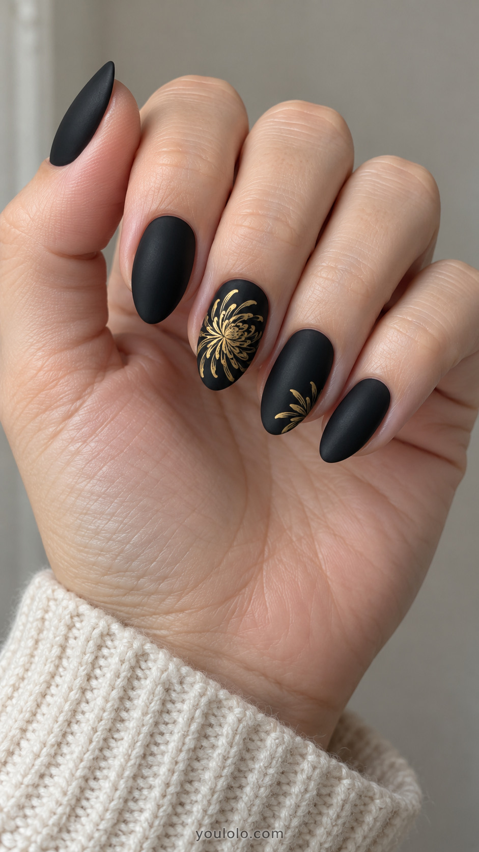 Matte-black almond nails with delicate gold chrysanthemum linework