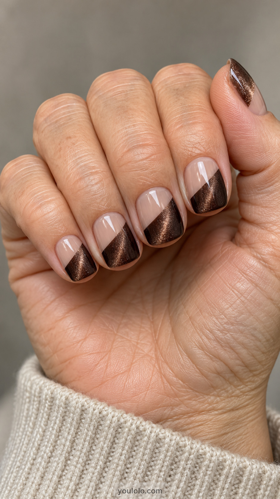 Short square nails: all nails sheer beige with lower diagonal half painted dark cocoa magnetic velvet, crisp diagonal border, no metallic edging.