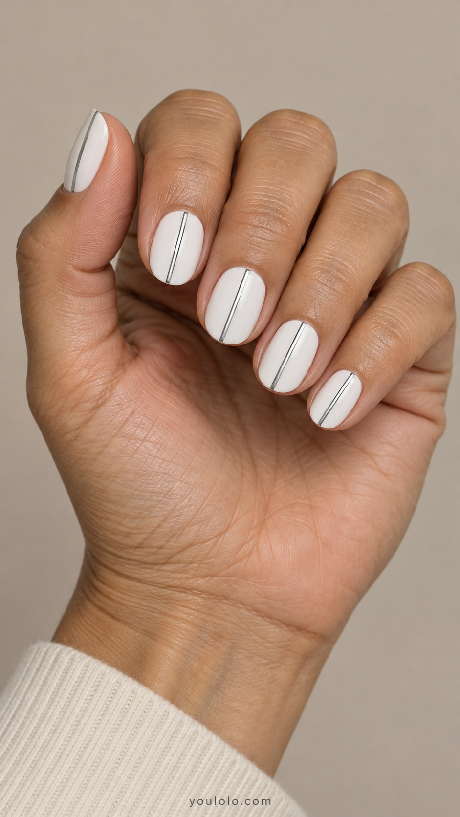 Short white oval nails with one narrow silver pinstripe per nail