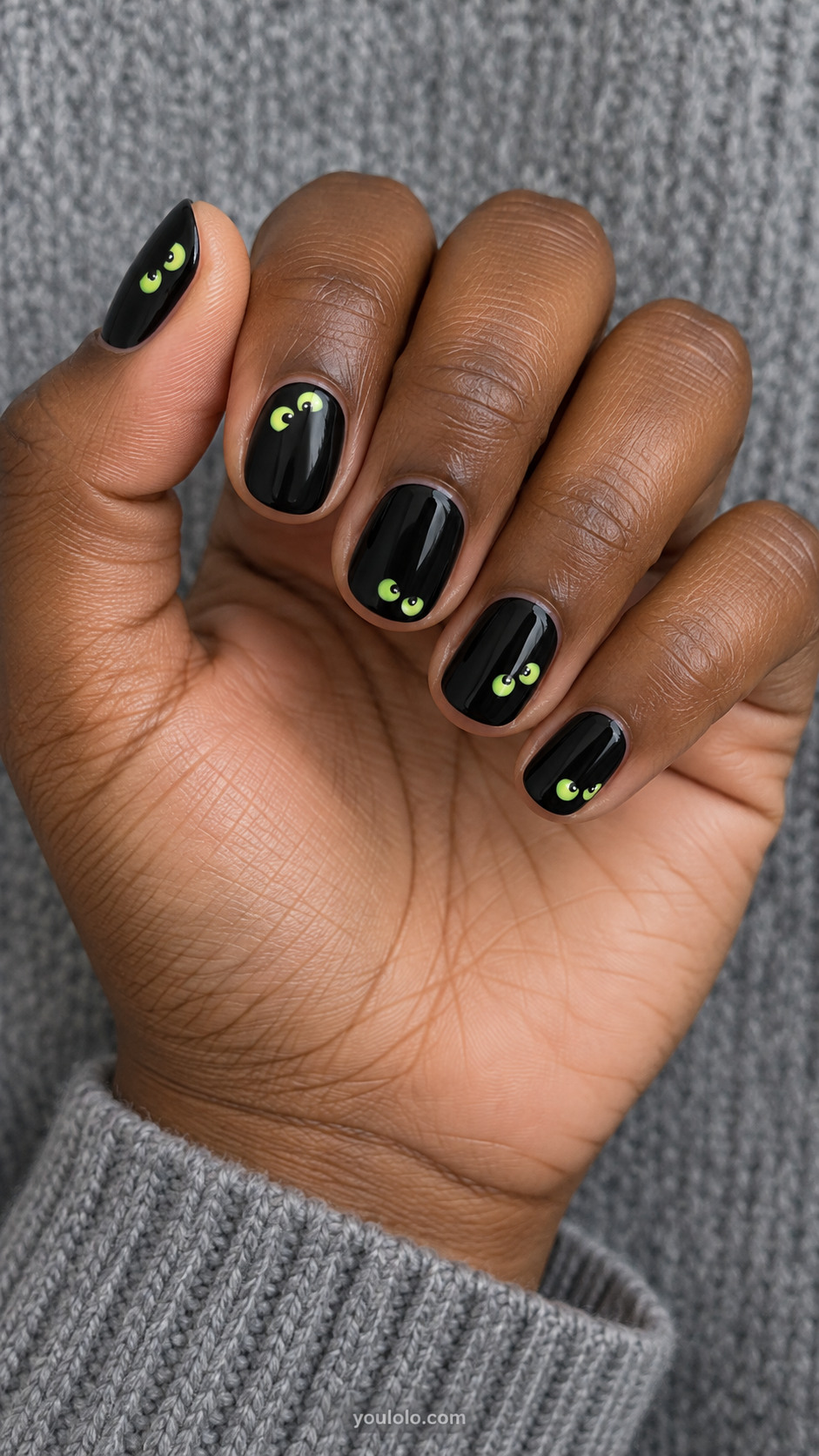 Short round shiny black nails pairs of tiny different lime-green monster eyes peeping from different edges, no raised decorations