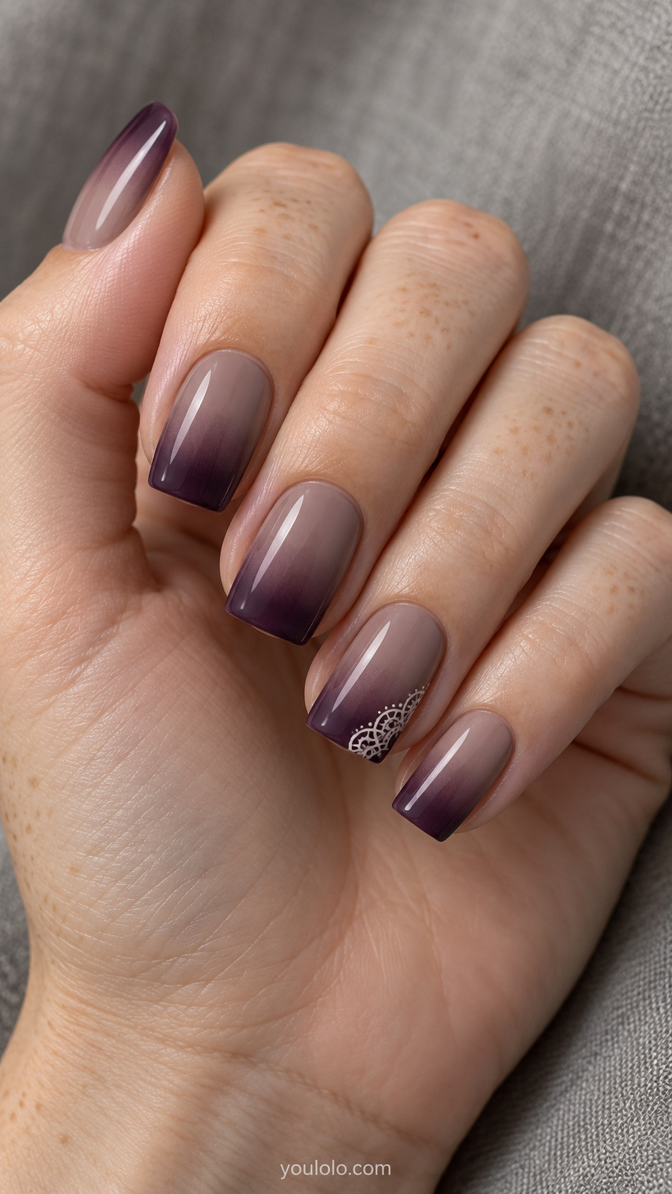 Taupe-to-plum square nails with a small ivory lace corner