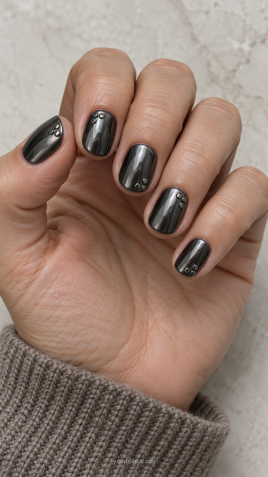 Short oval all dark gunmetal chrome nails with groups of three tiny flat gunmetal studs in triangular arrangements at different corners