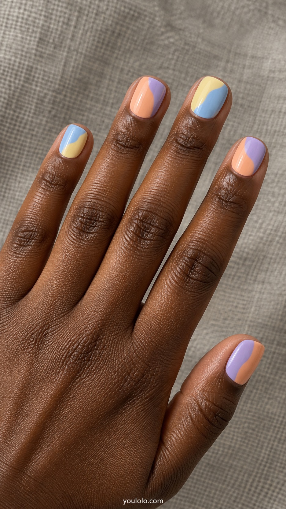 Short Artsy Nails: Pastel Patchwork manicure on a naturally posed hand