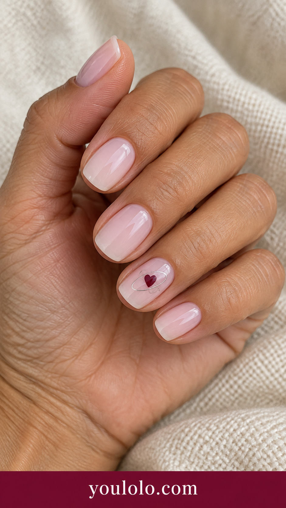 Heart Orbit: short soft square milky pink nails ring nail small burgundy heart with thin silver partial oval orbit line around it on a naturally posed adult hand