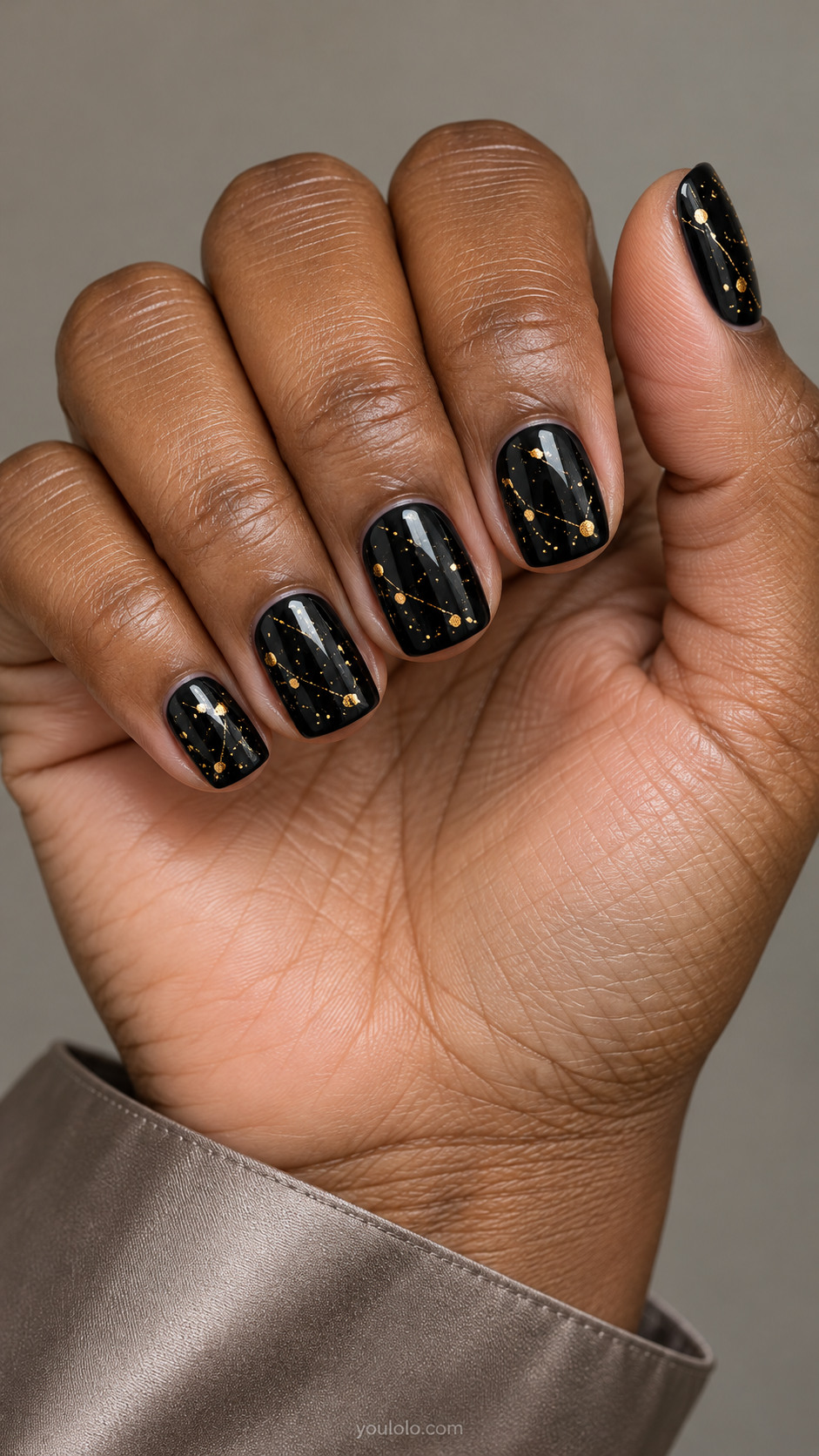 Short black square nails with fine gold paint splashes and tiny droplets
