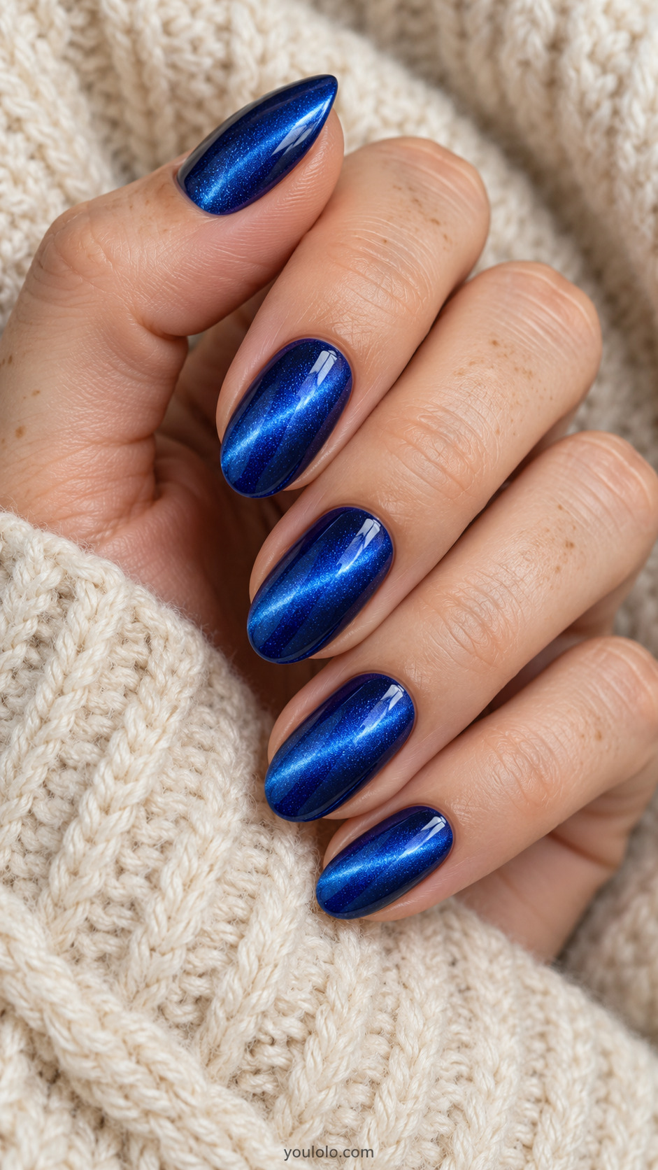 Royal blue oval nails with luminous diagonal cat-eye bands