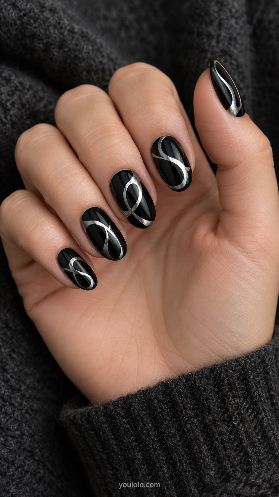 Medium oval glossy black nails broad reflective silver fluid looping strokes, one elegant irregular loop per nail, balanced variation, no text no letterforms