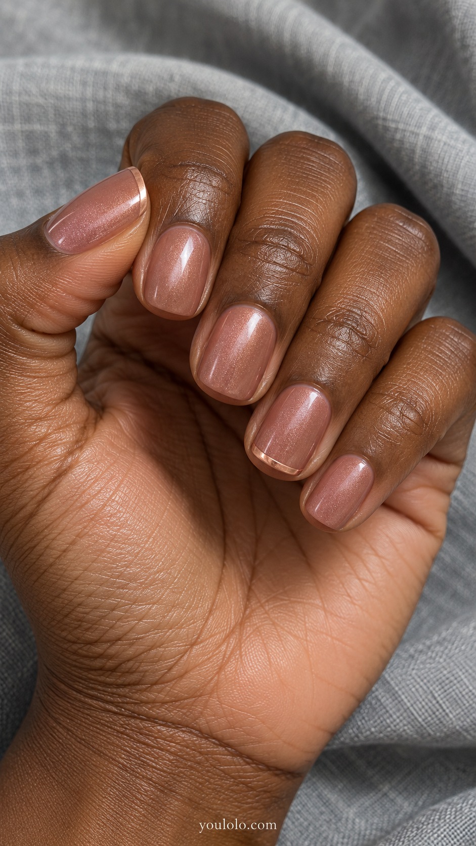 Short squoval nails light cocoa rose brown base with subtle rosy pearl finish, thumb and ring fine pale rose gold tip outline