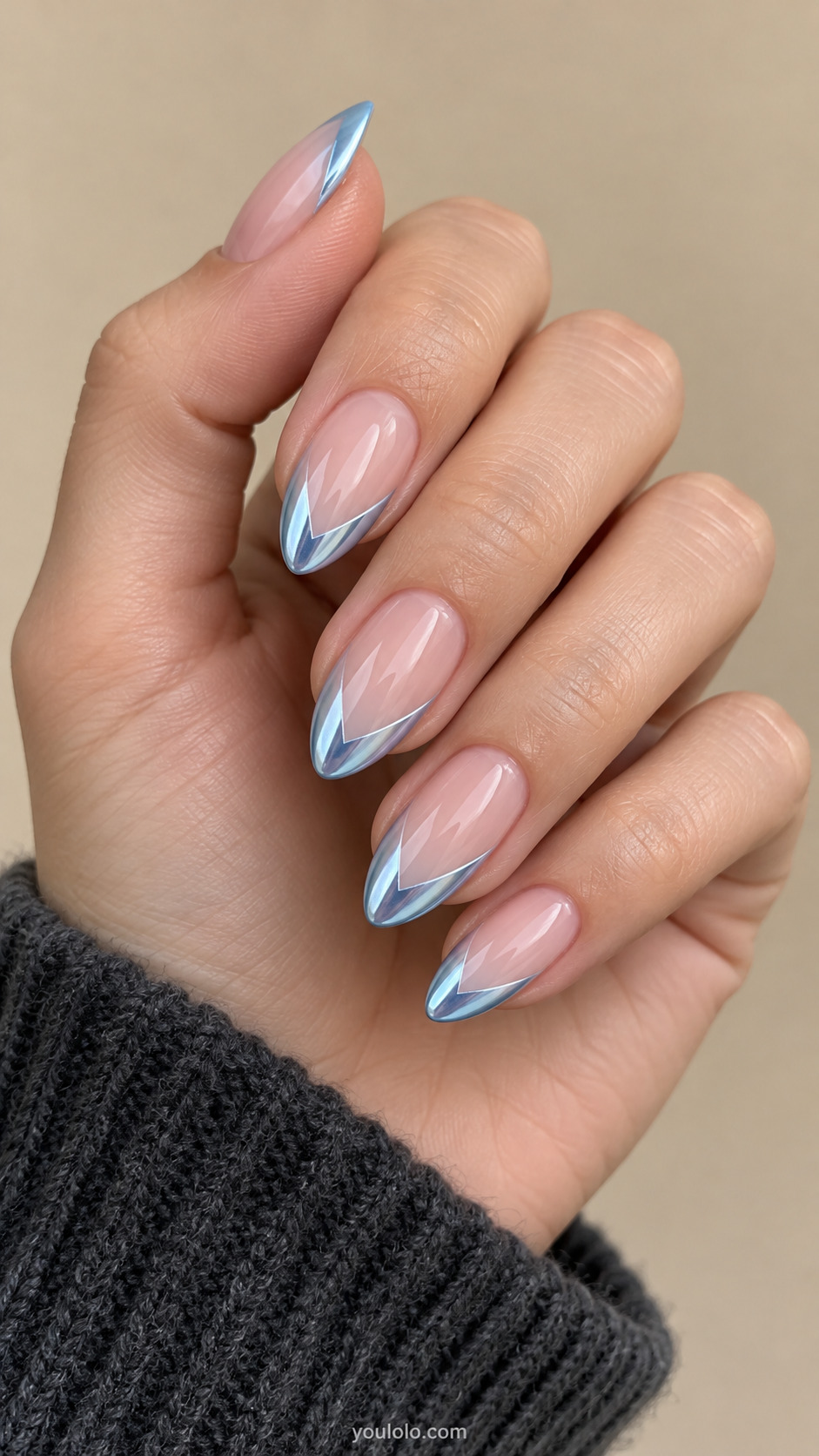 Sheer pink almond nails with symmetrical icy-blue chrome chevron tips.