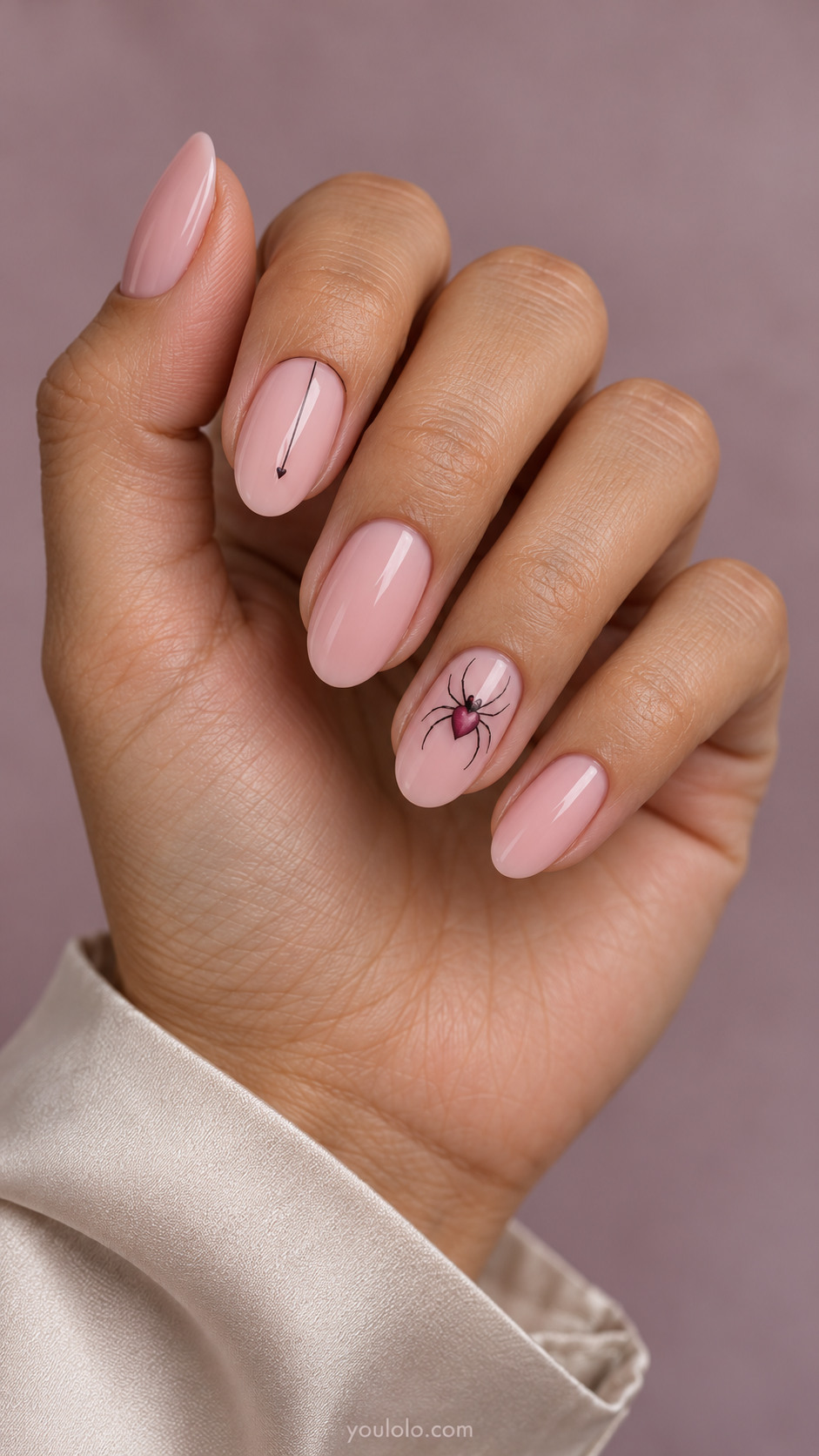 Blush pink nails with a raspberry heart-bodied spider and thin thread