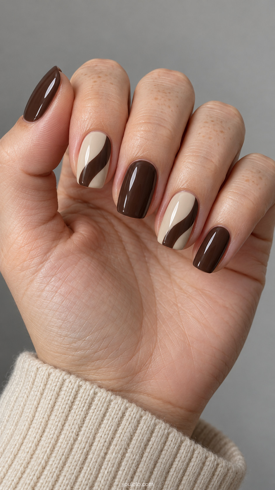 Medium squoval nails: oat nails with broad espresso curved arc entering one side on alternate nails, remaining solid espresso, no French tips.