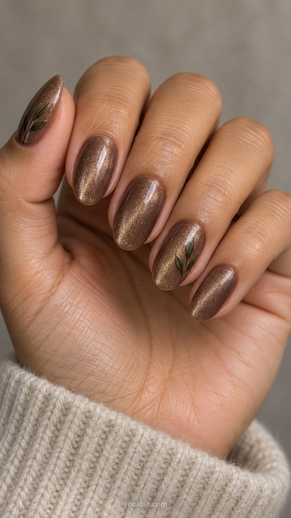 Medium oval nails: medium mocha magnetic velvet all nails; ring and thumb have a tiny flat dark olive painted sprig with three narrow leaves on a fine stem.