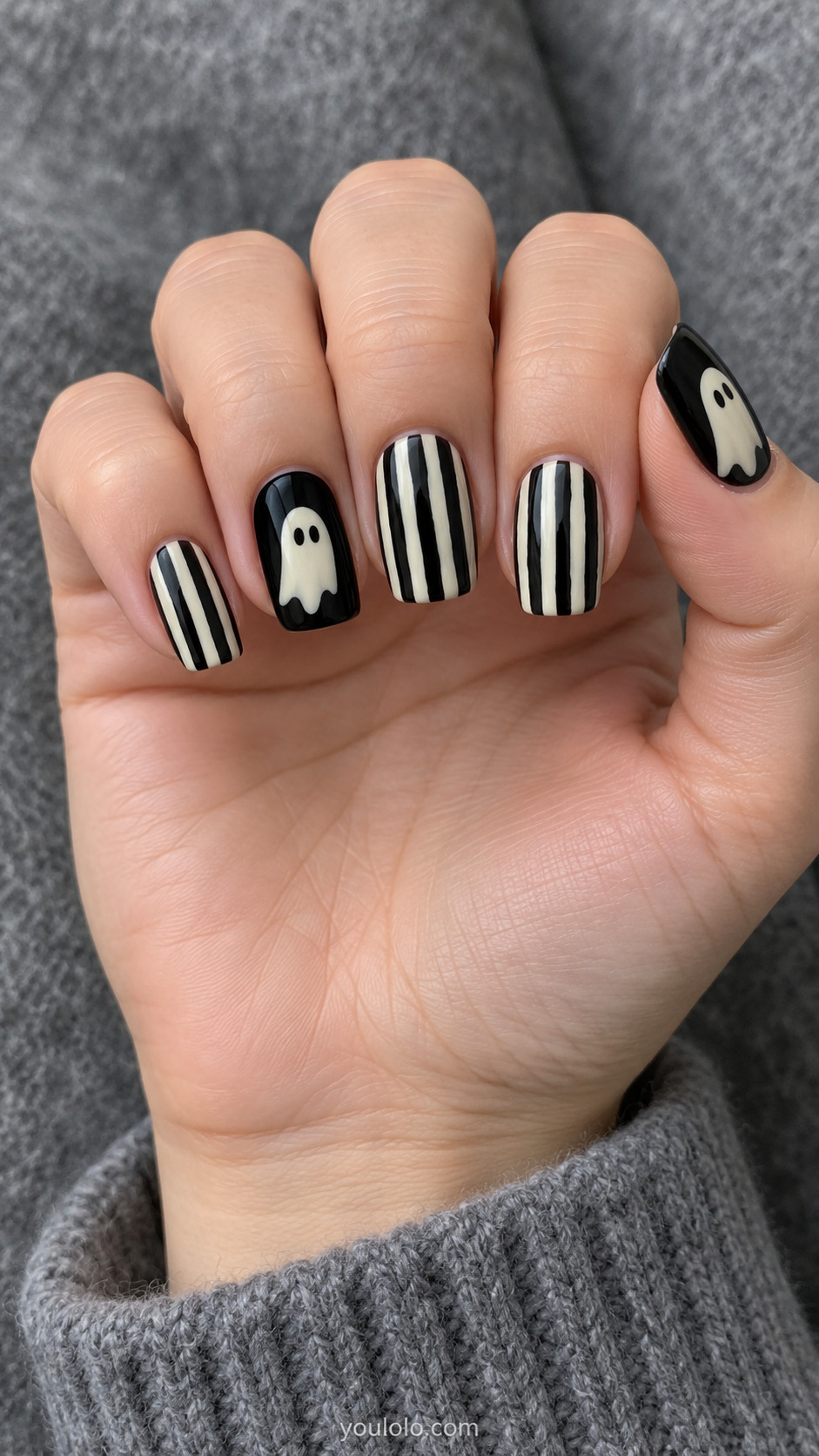 Medium square nails handpainted irregular black and cream narrow vertical stripes on three nails, black nails with one offwhite oval ghost silhouette on other two