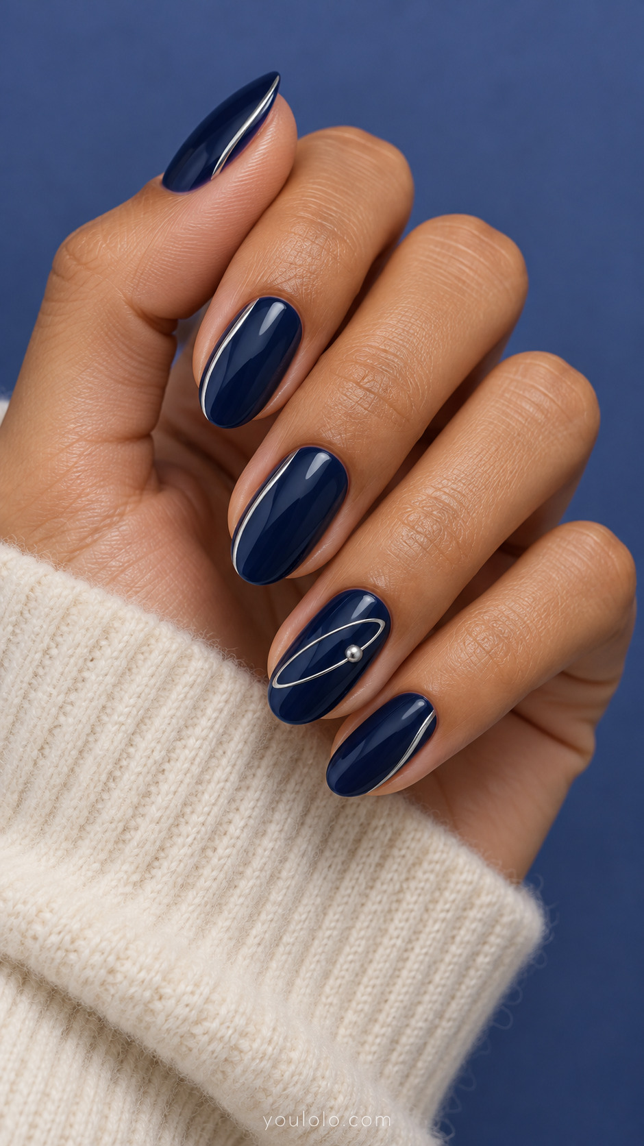 Navy oval nails with silver side lines; one elliptical silver orbit and tiny metallic dot.