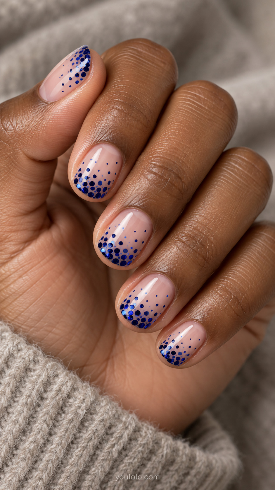 Sapphire Dotted Gradient on Nude on a softly gathered feminine hand with detailed sapphire blue manicure