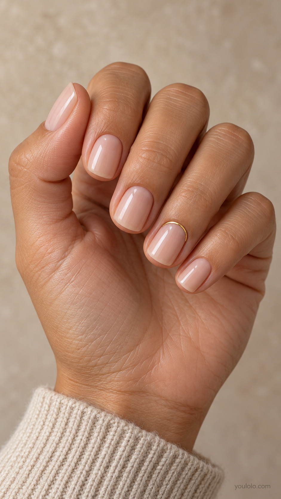 Short squoval nails with sheer pink beige polish and a fine gold cuticle arc on the ring nail.