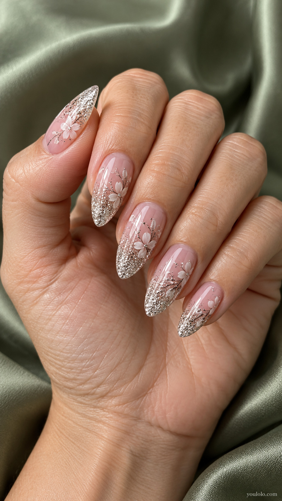 Long pink almond nails with silver glitter tips and delicate white flowers