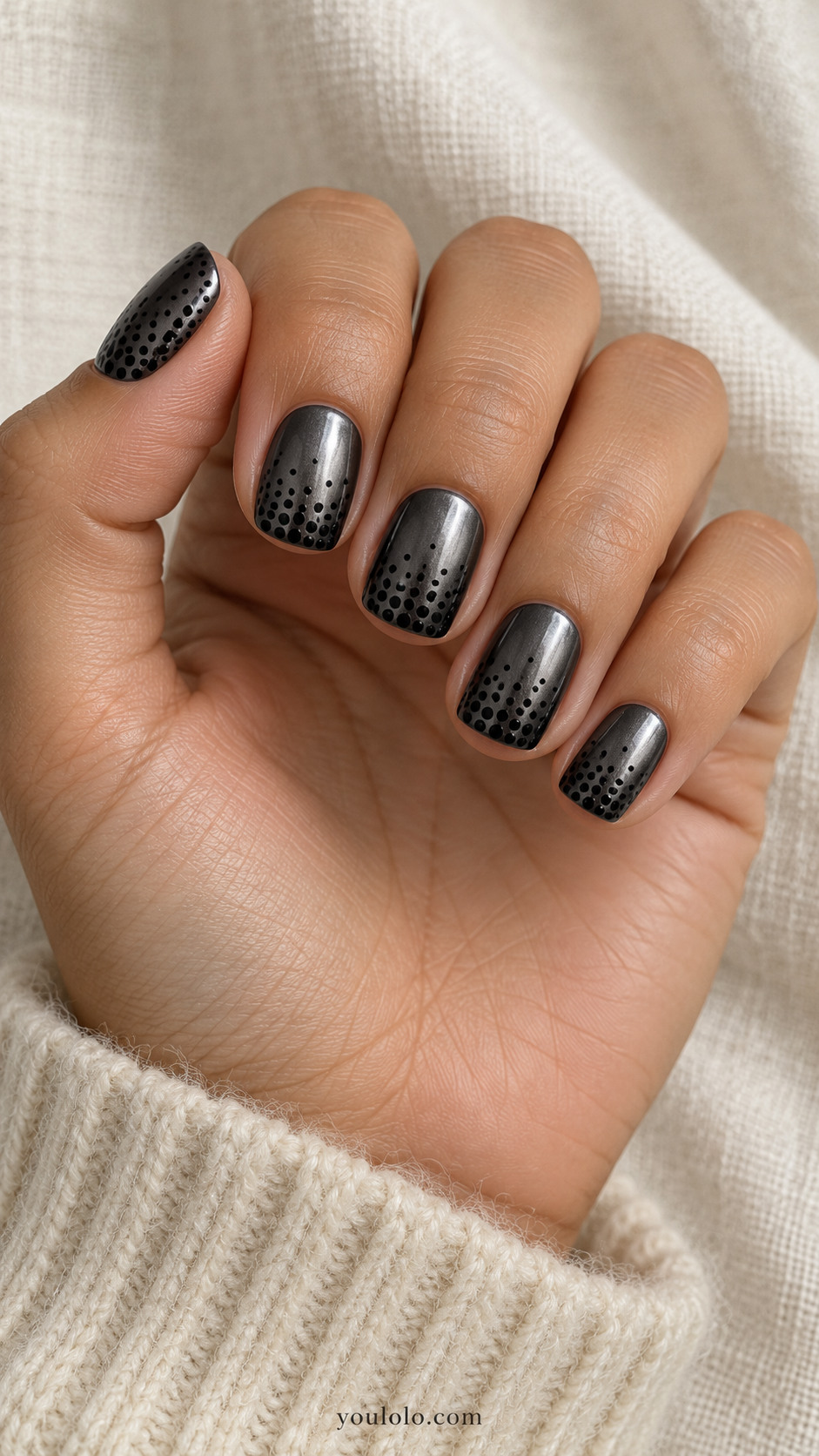 Short squoval dark gunmetal chrome nails with tiny flat matte-black painted dots graduating from dense at tips to sparse halfway down
