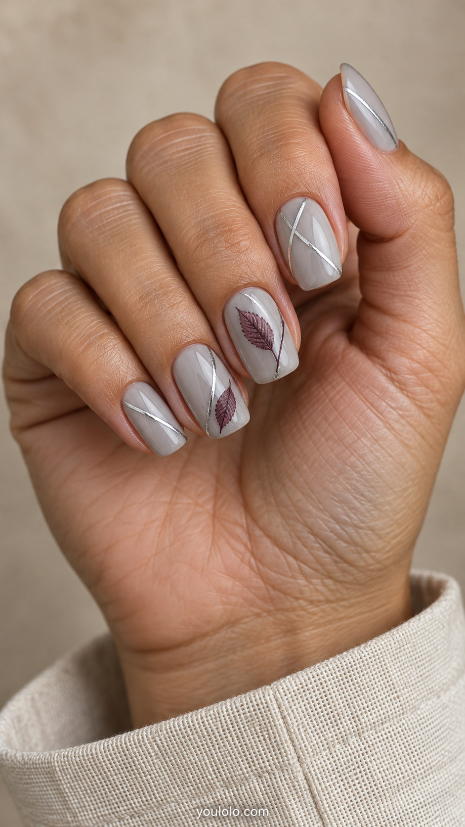 Milky gray squoval nails with fine silver lines and plum leaf accents on the middle and ring fingers.