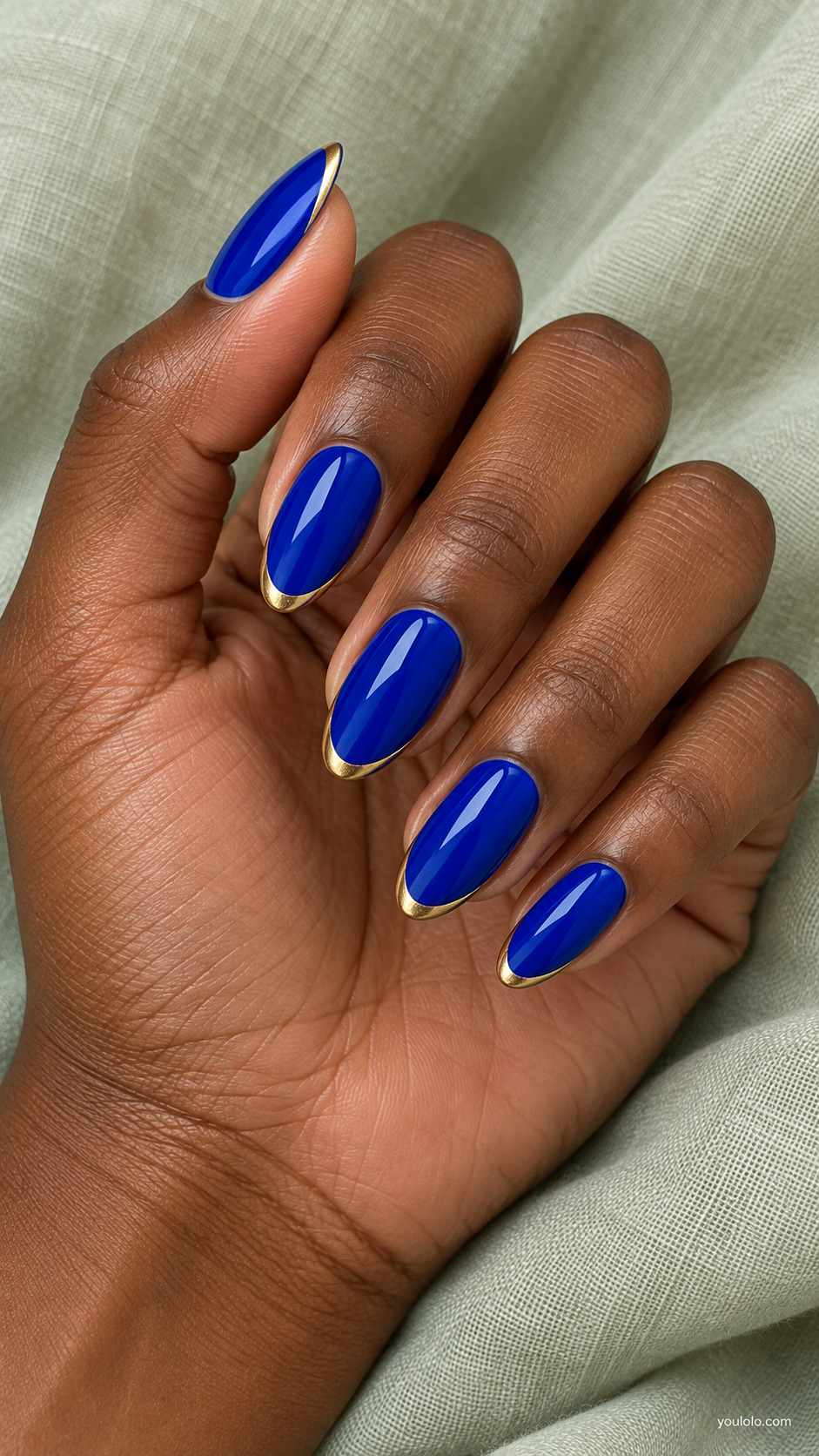 Royal blue almond nails with narrow metallic gold French tips