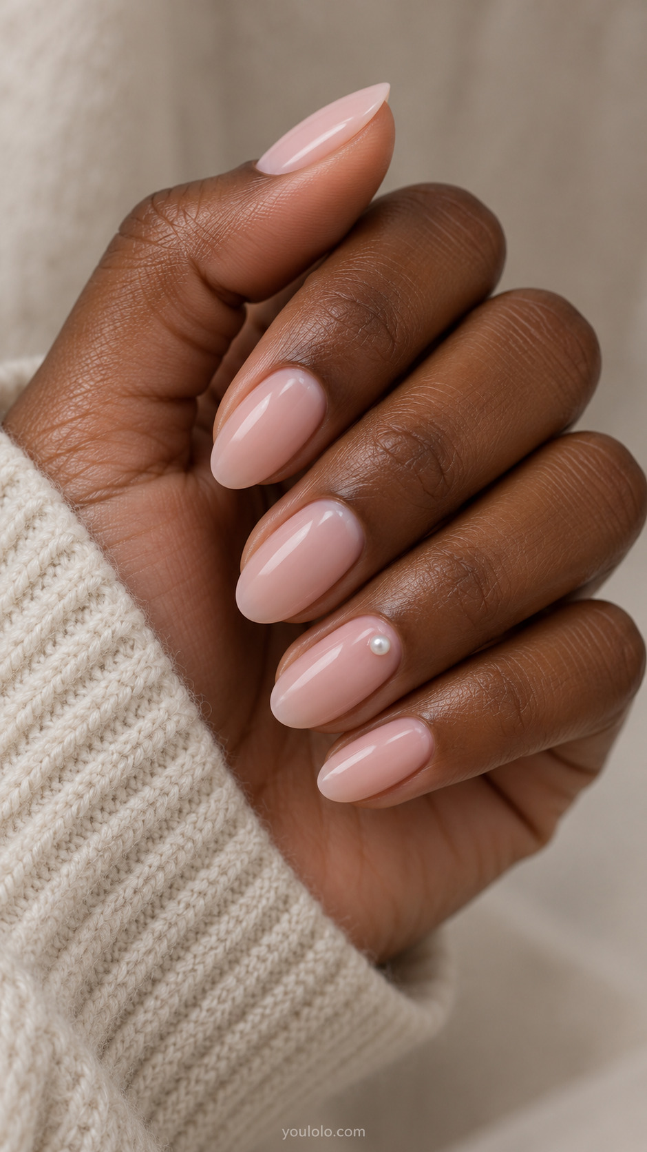Medium oval milky pink nails with a tiny pearl accent near the base of the ring nail.