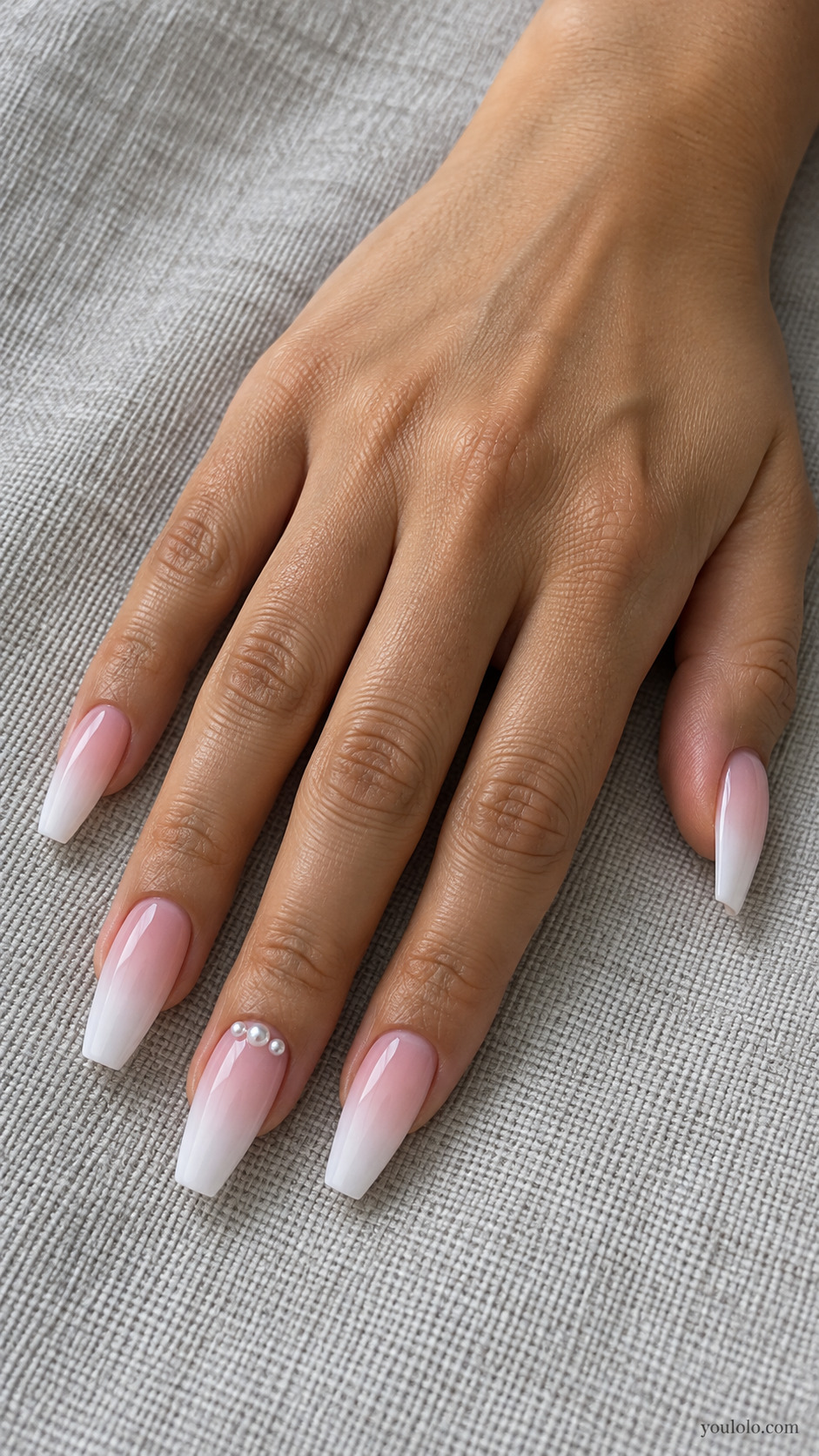 Long pink-to-white coffin ombre nails with a small pearl accent