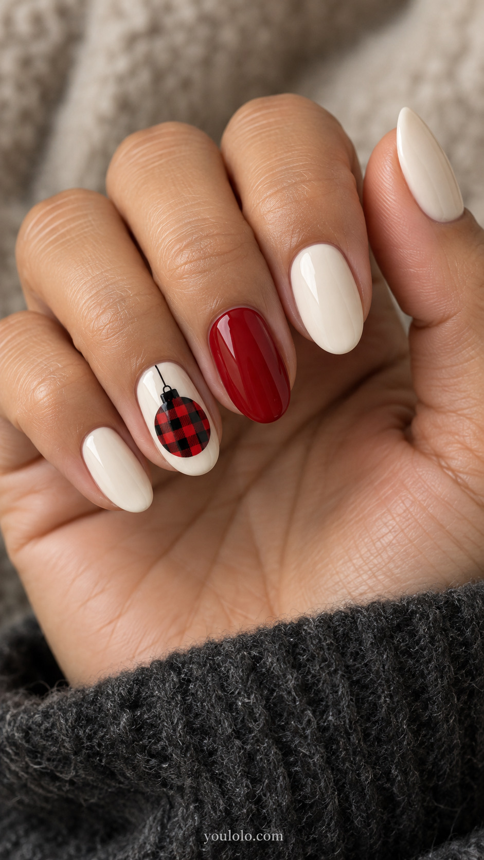 Cream nails with a red-and-black checked ornament accent
