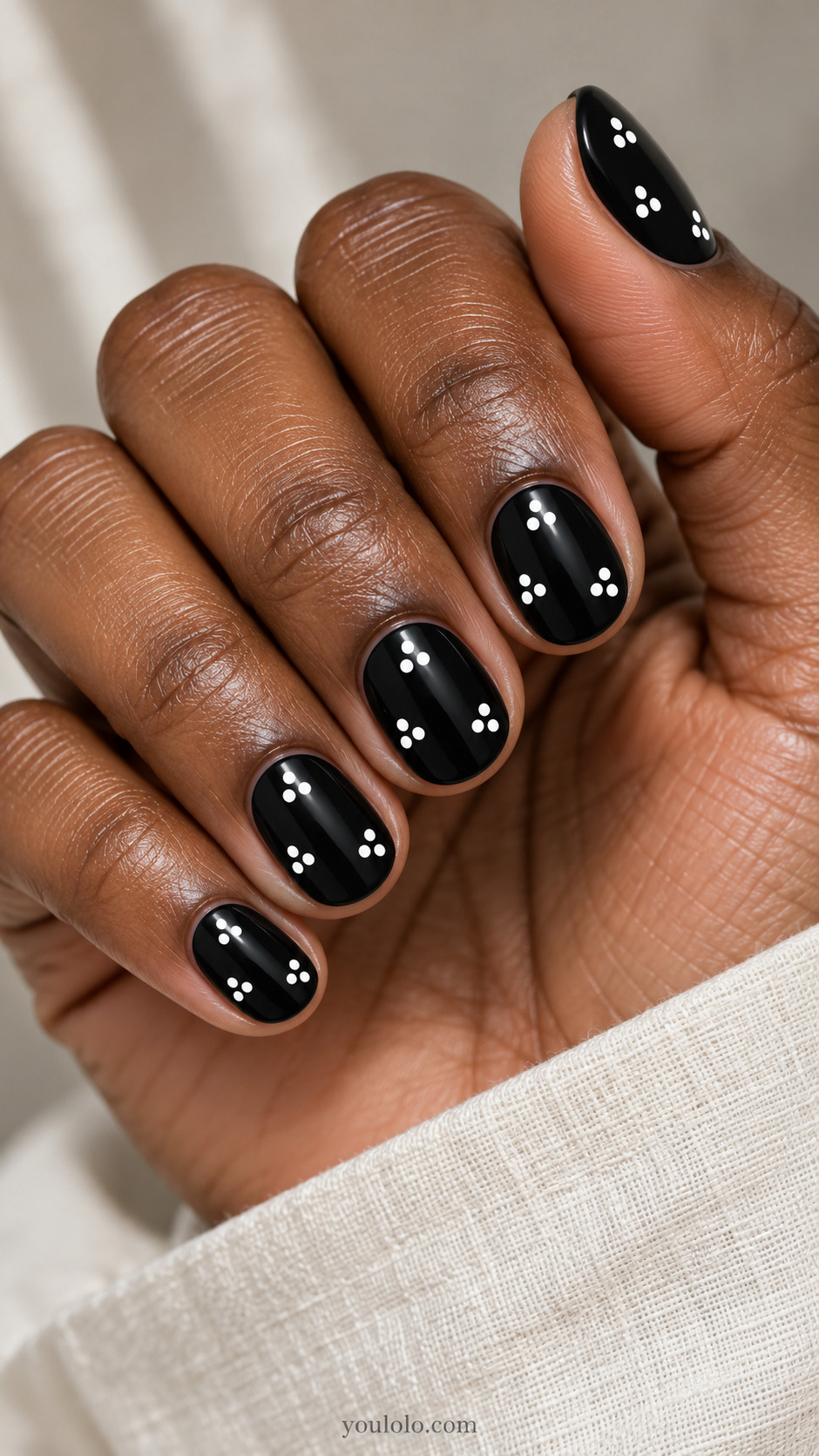 Short oval black nails with three separate groups of three white dots each arranged triangle, large empty spaces between groups