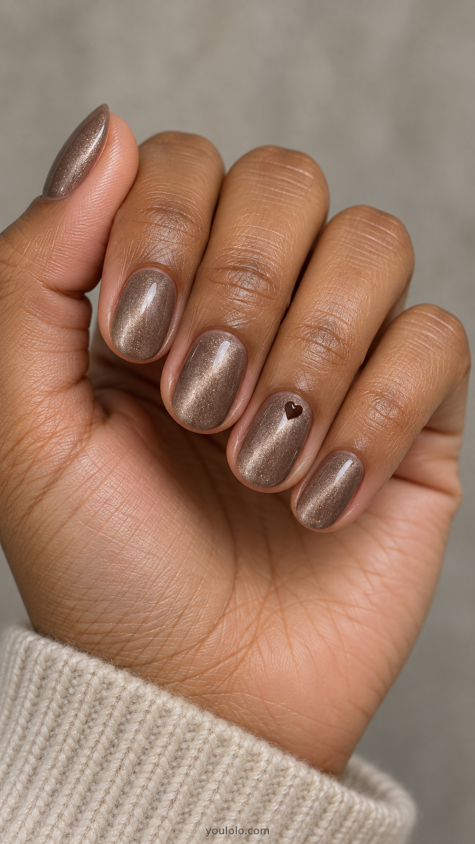 Short oval nails: light taupe-brown magnetic velvet nails, ring has one tiny opaque dark chocolate painted heart near side of cuticle, others plain.