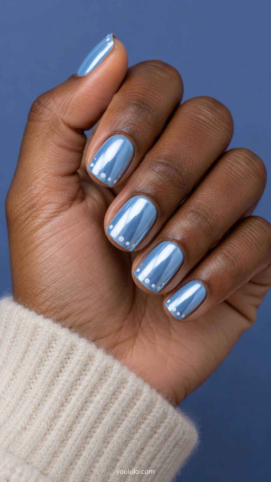 Short icy-blue chrome squoval nails with sparse tiny white snow dots near the tips.