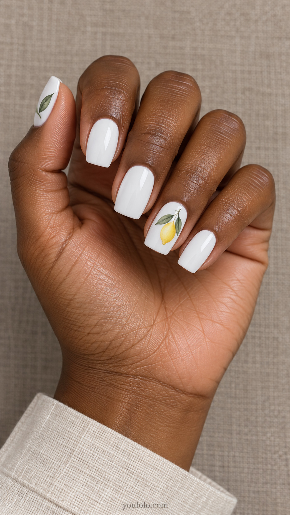 White square nails with a tiny lemon branch and a leaf on the thumb