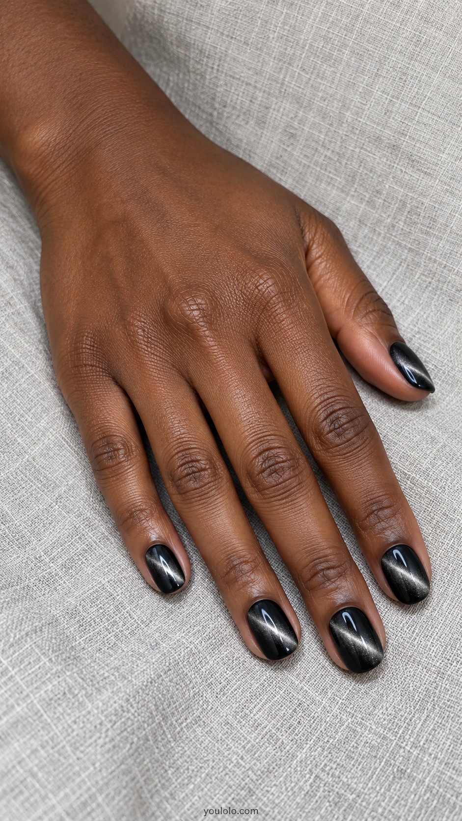 Black with a Silver Slash cat eye nails — Short oval black nails with bright narrow diagonal silver magnetic beams.