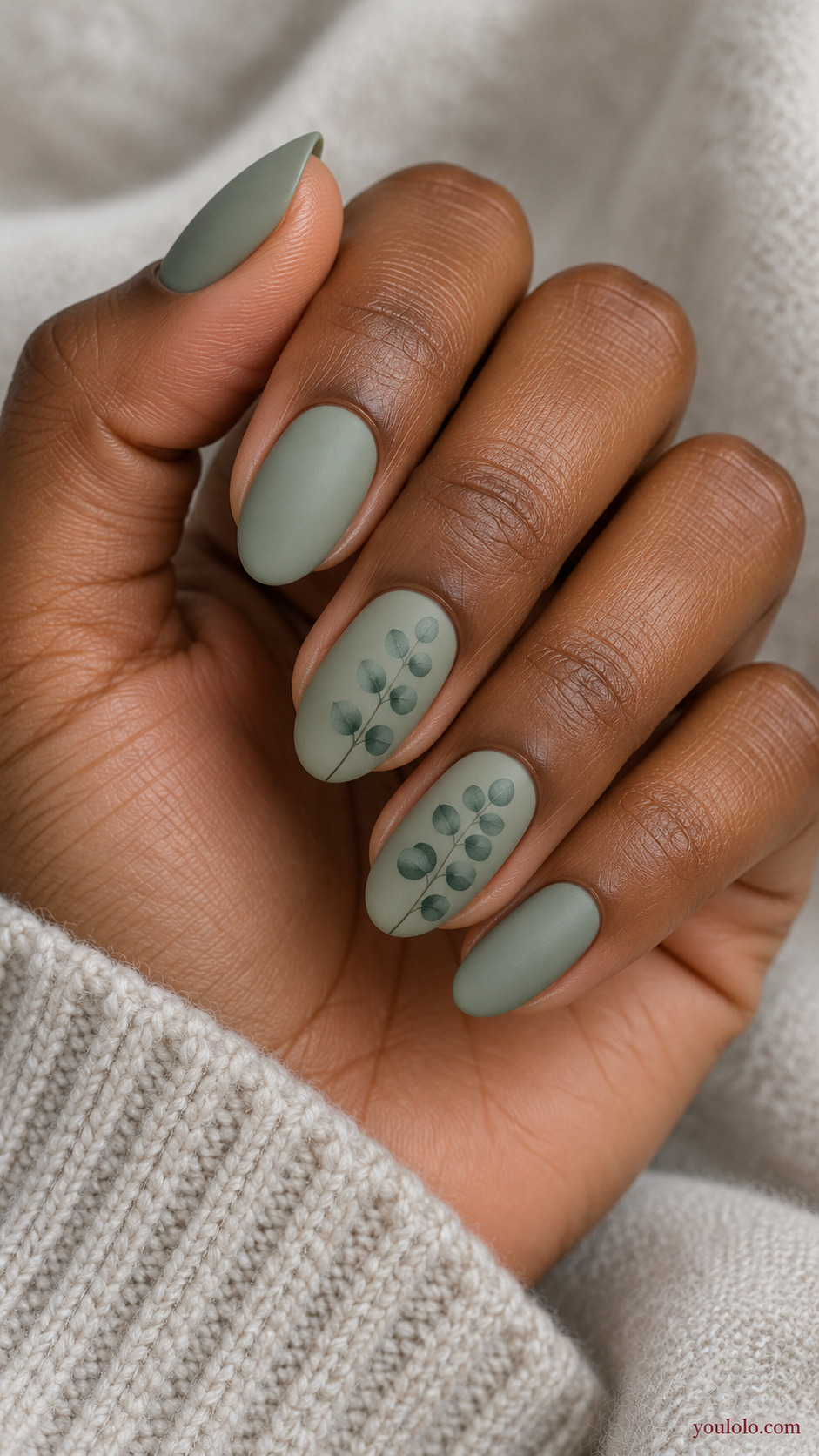 Fine Eucalyptus Sprigs on a softly gathered feminine hand with a matte green manicure