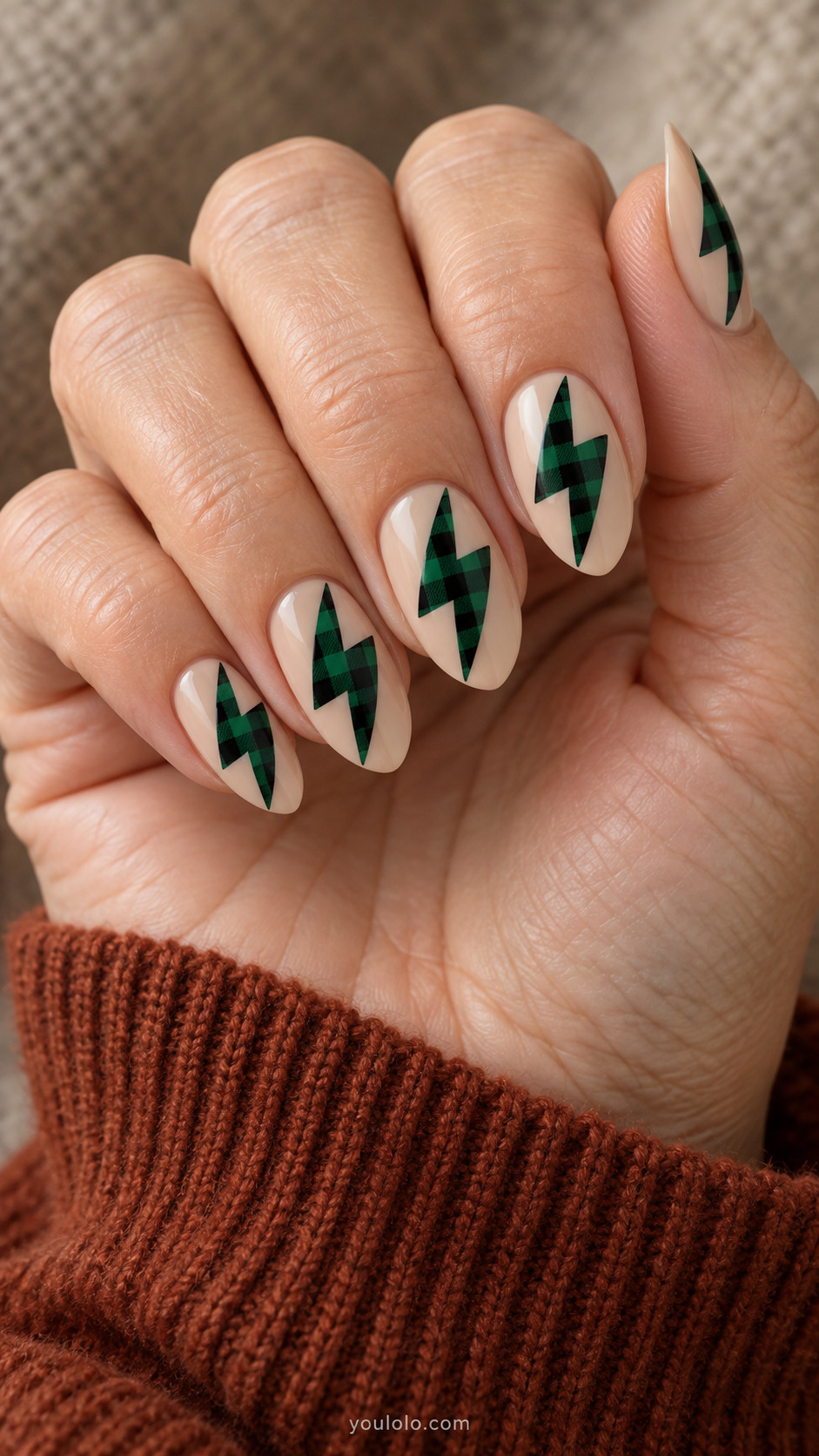 Milky beige almond nails with forest-green buffalo check lightning bolt shapes