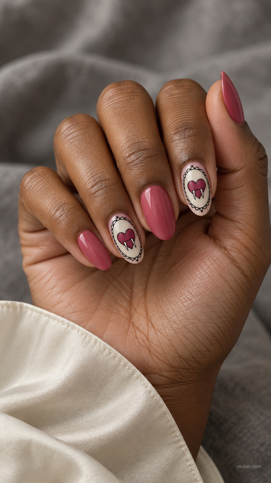 Dusty rose almond nails with scalloped heart cameos and tiny fangs