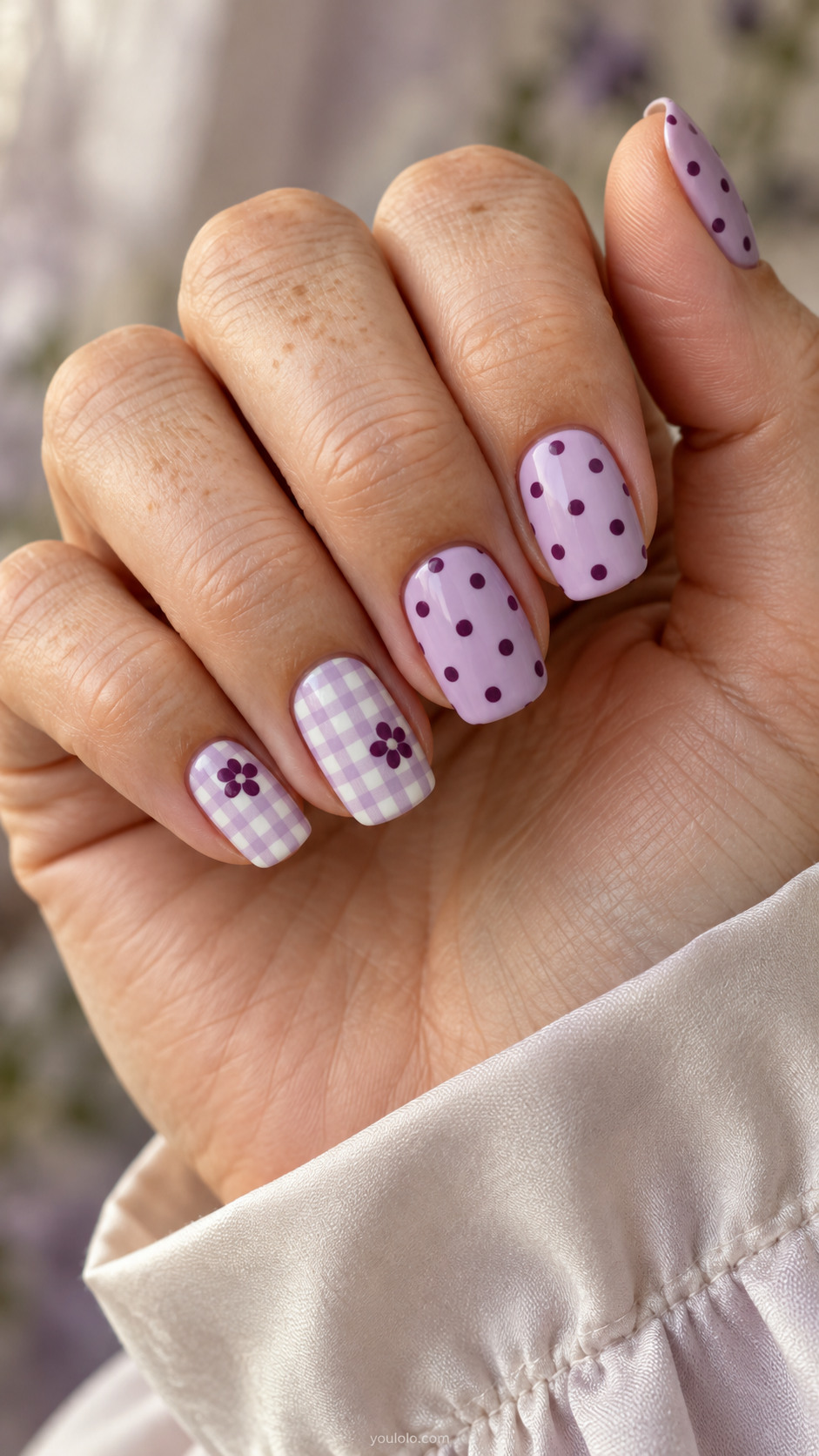 Lilac squoval nails with plum dots and fine gingham floral accents.