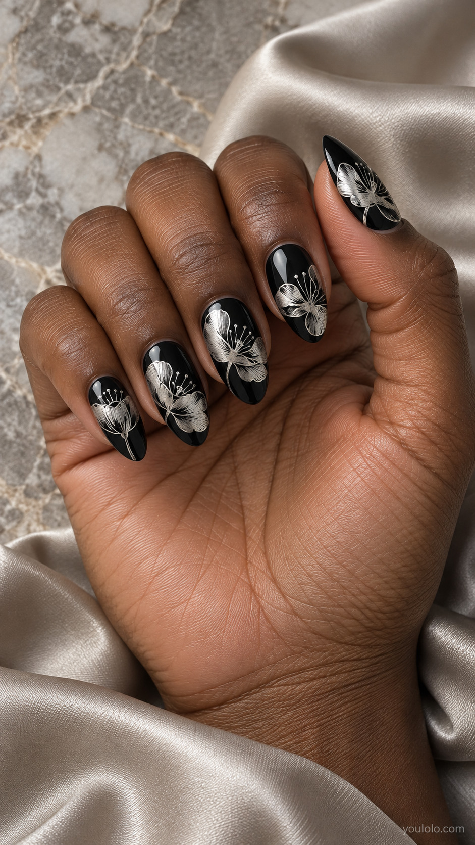 Medium almond black nails flat metallic silver delicate open poppy flower line art, large asymmetric petals and fine stamens, single flower per nail varied placement
