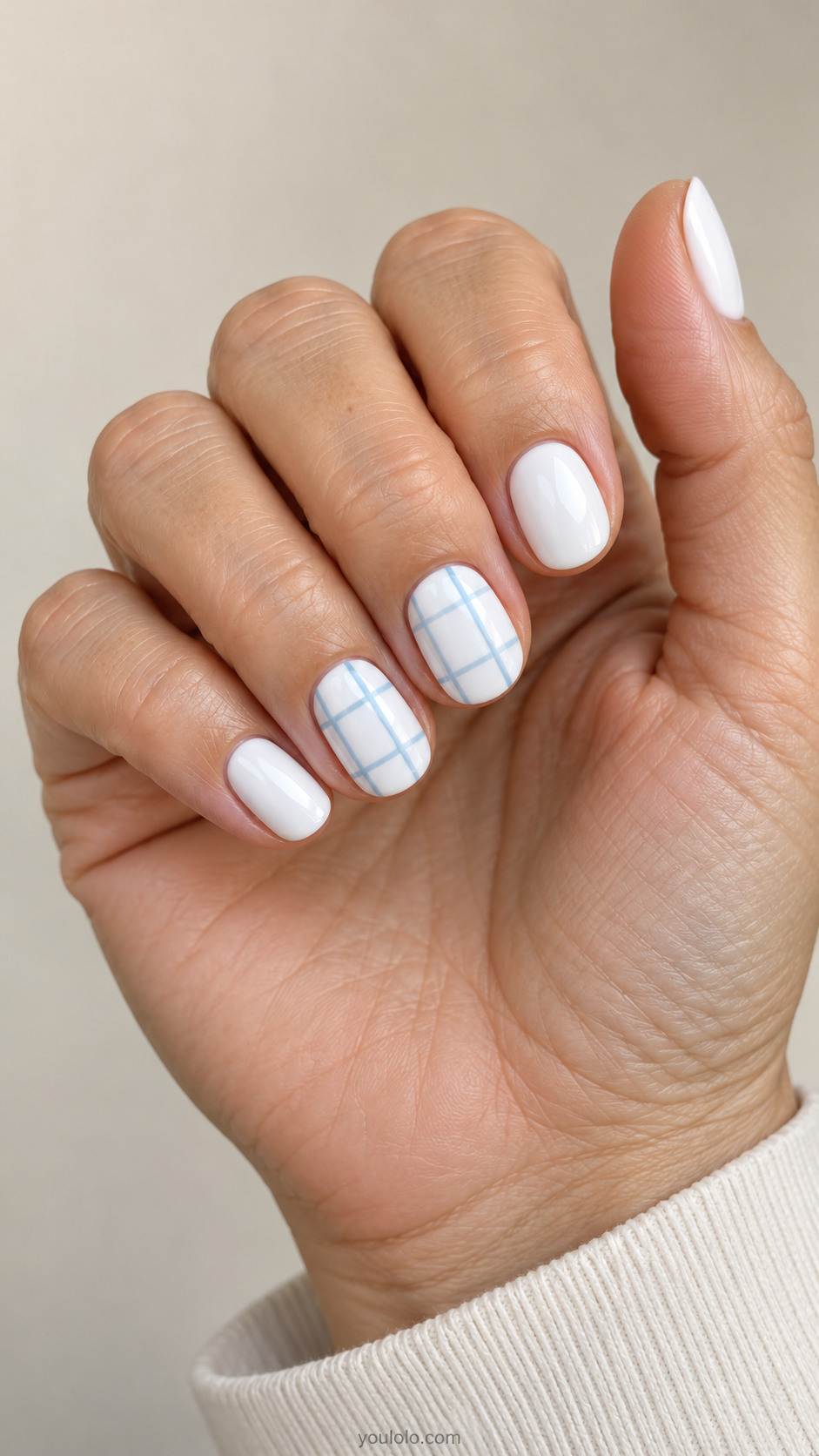 Short white oval nails with powder blue windowpane lines on two nails