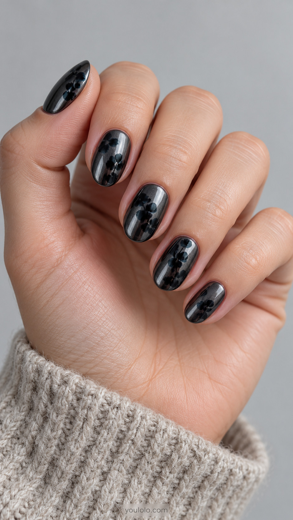 Short dark chrome almond nails with small diffused black blooming flowers
