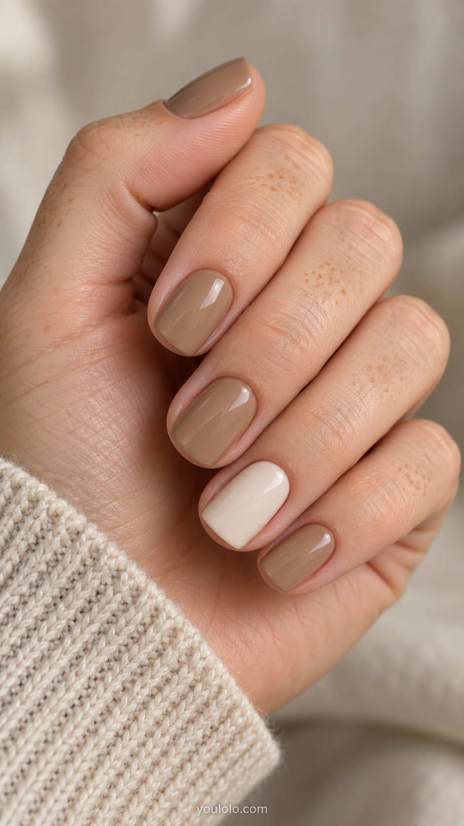 Short squoval camel beige nails with a warm ivory ring nail accent.