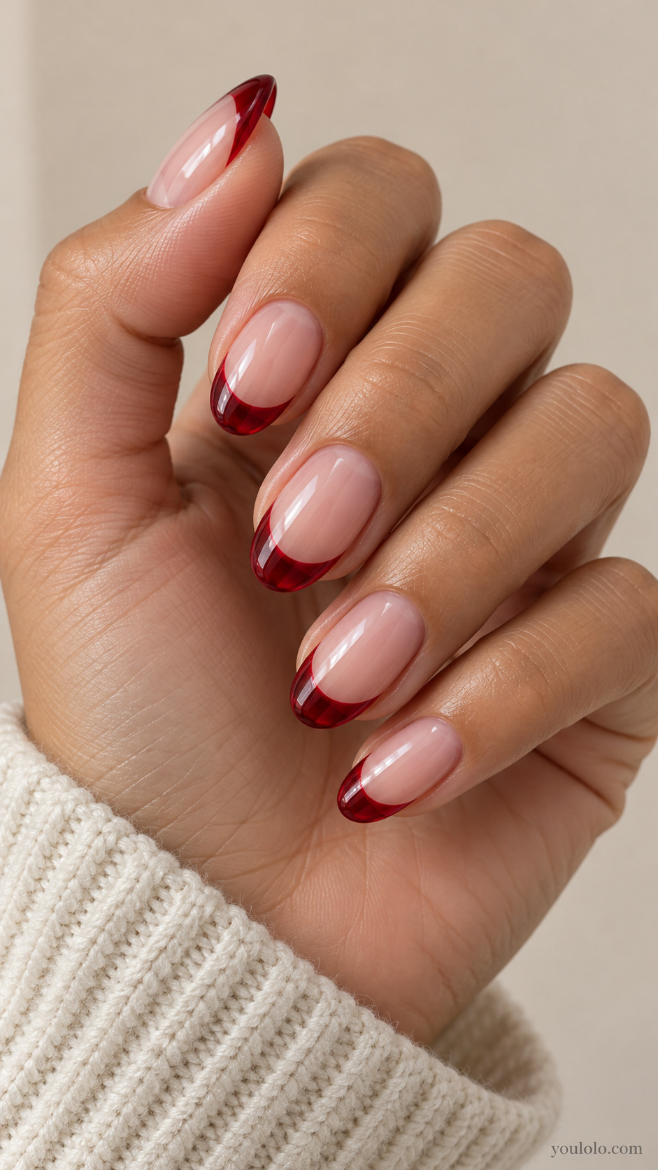 medium oval translucent pale pink nails, translucent cherry red jelly French tips visibly see-through at free edges on a naturally gathered hand
