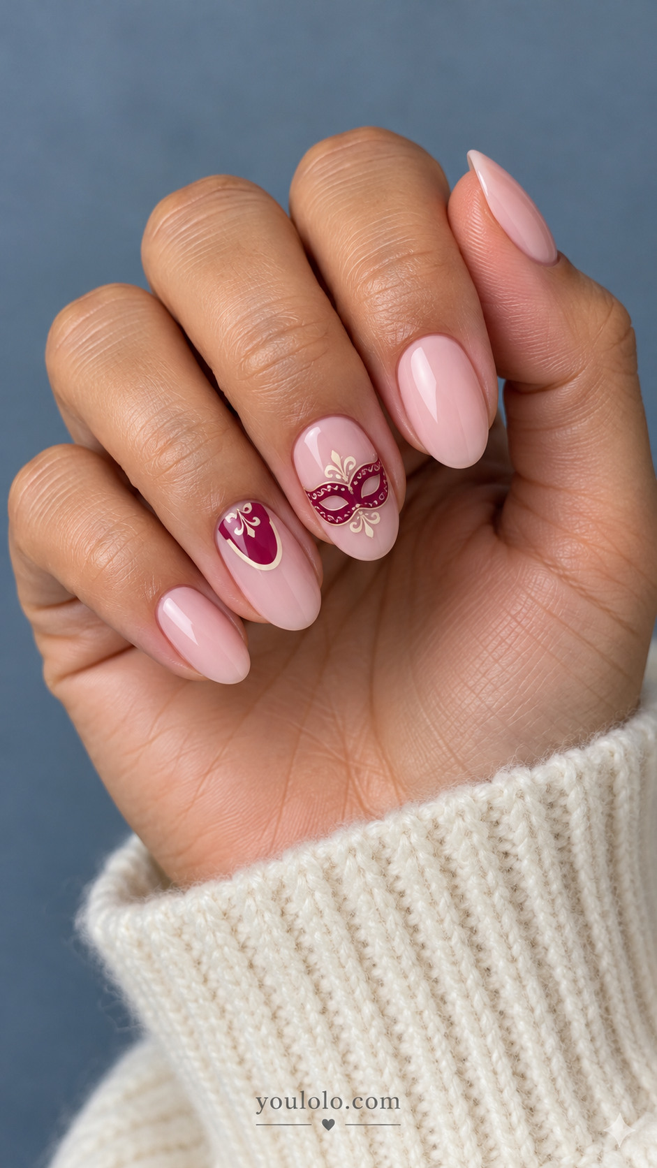 Milky pink almond nails with a berry masquerade mask and cream scroll accents