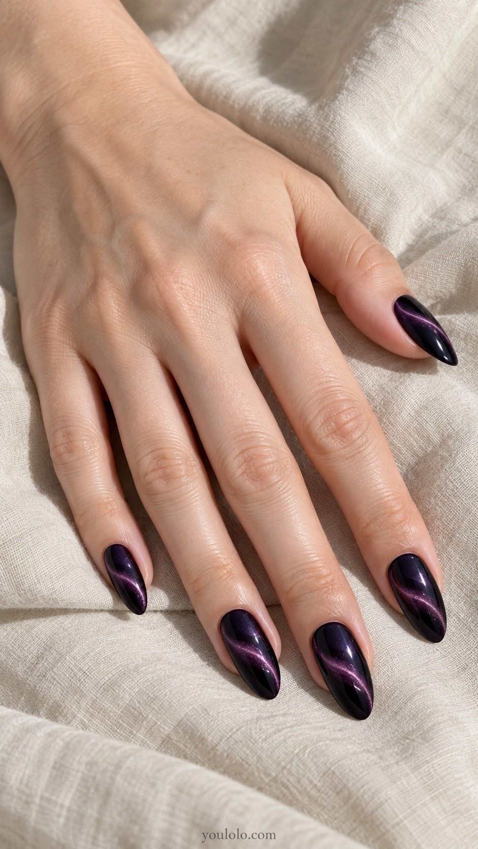 Black and Plum with a Fine Swirl cat eye nails — Medium almond black base magnetic purple shimmer with one narrow smoky plum curved painted ribbon across each nail.