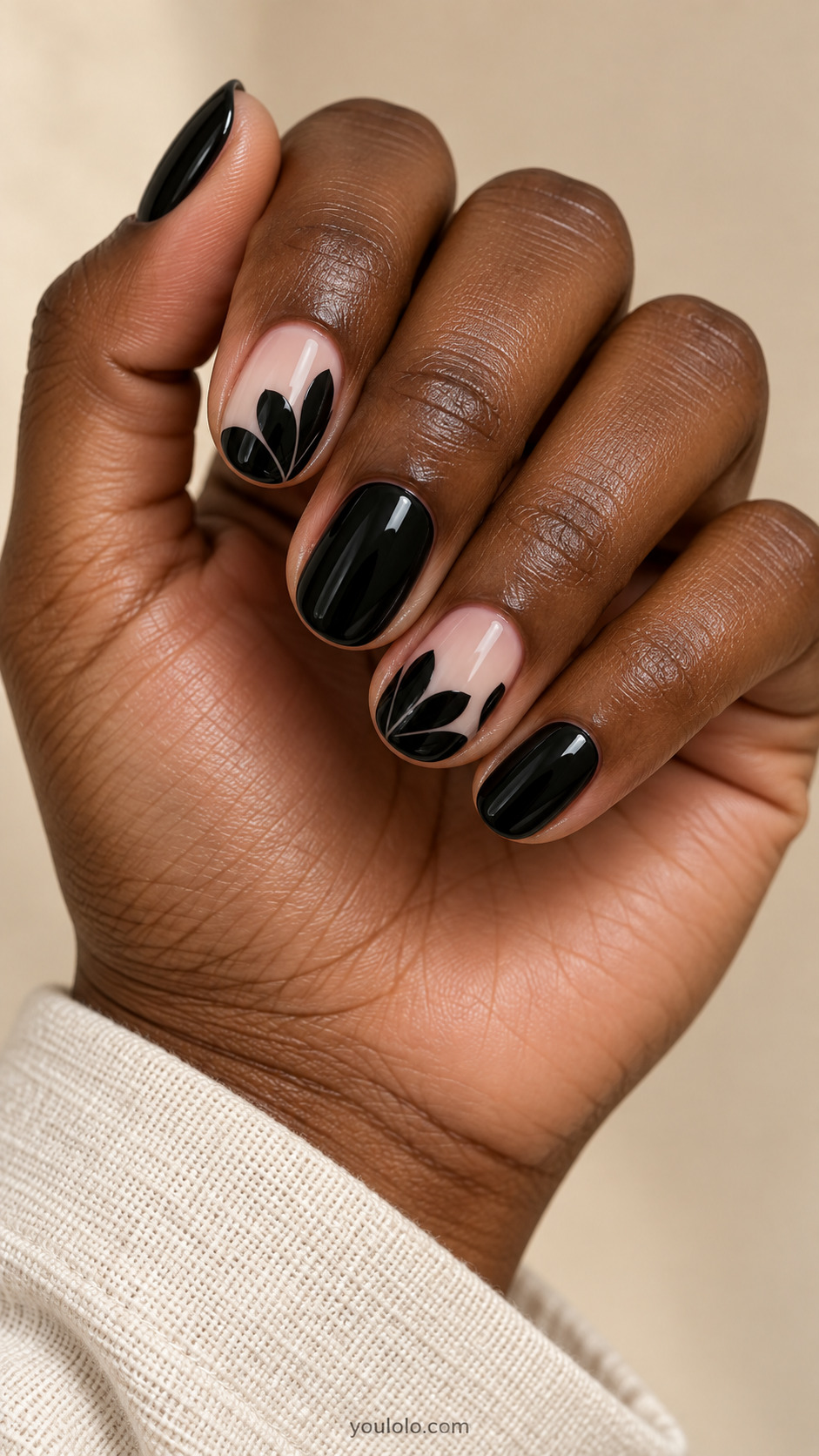 Short black nails alternating with nude and black petal silhouettes