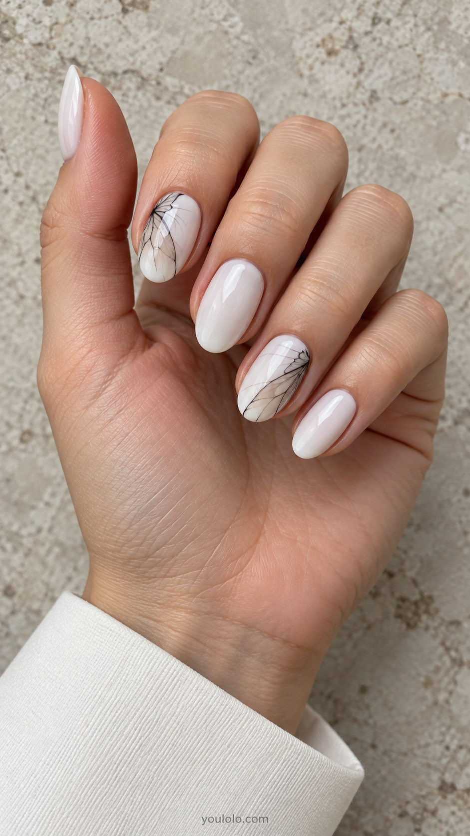 White oval nails with fine charcoal butterfly wing fragments on two corners