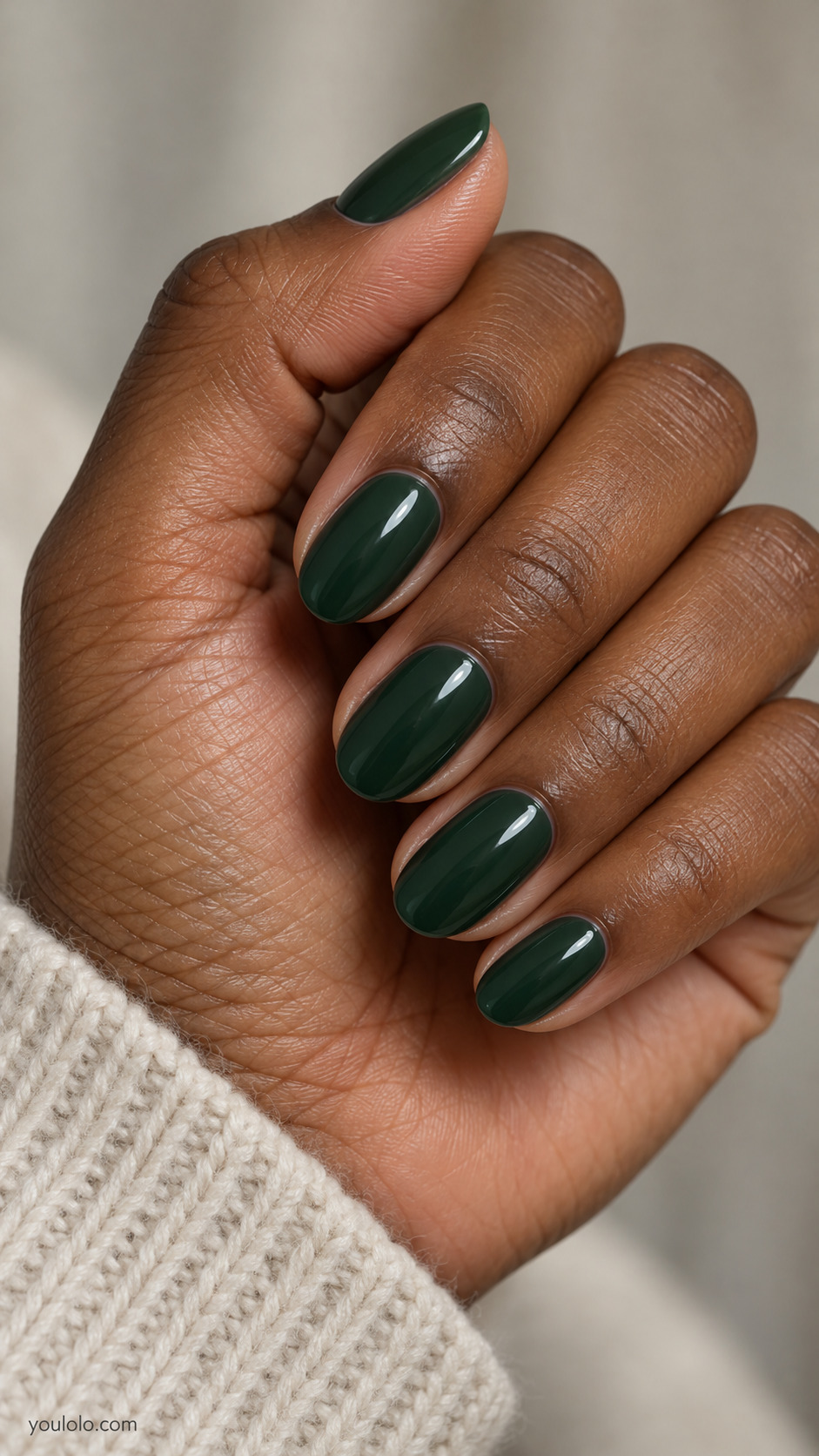 Short oval nails painted glossy deep forest green.