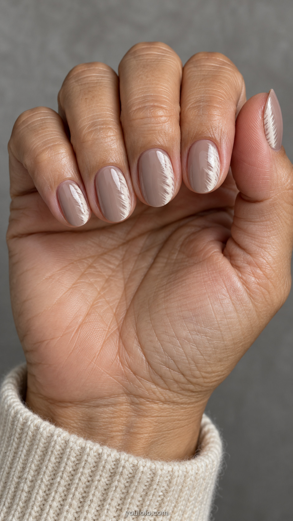 Short oval nails: sheer taupe nails with soft ivory feathered brush fringe along one side edge only, abstract fine brush texture no actual feathers.