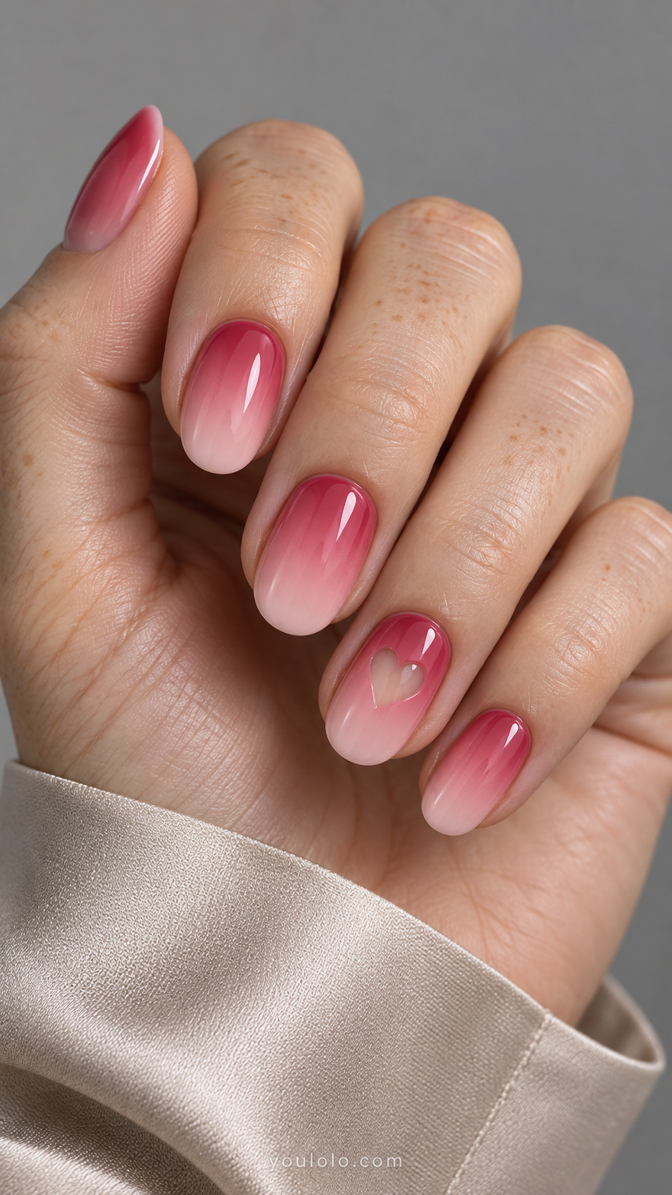 Raspberry-to-blush oval nails with a small nude heart window